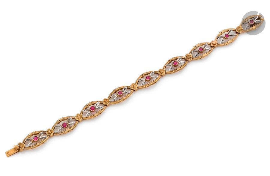 Bracelet en or 18K (750), articulé de maillons ovales agrémentés chacun d’un rubis rond et de diamants taillés en roses, scandés de fleurettes. Travail français régional antérieur à 1919. 
Dimensions : 1 x 18,4 cm environ. 
Poids brut : 14,5 g