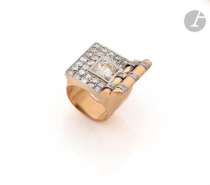 Bague asymétrique en or rose 18K (750), ornée d’un diamant rond de taille ancienne dans des diamants ronds pavés, l’épaulement appliqué d’un côté de barrettes serties de diamants ronds. Travail français des années 1940. 
Tour de doigt : 52/53. 
Poids brut : 14,5 g (chocs)