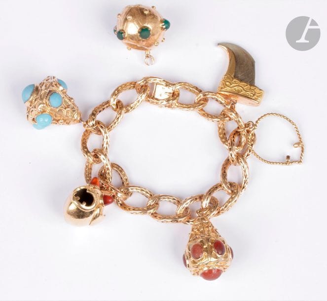 Bracelet en or 18K (750), articulé de maillons ovales, retenant en pampilles quatre pendeloques en or 18K, deux ornés de pâtes de verre de couleurs, une dessinant un poisson, les yeux en cornalines, la dernière sertie d’une griffe. 
Poids brut : 114,9 g (on joint une pampille en or et pâtes de verre vertes; enfoncements, accident, fermoir à réviser)