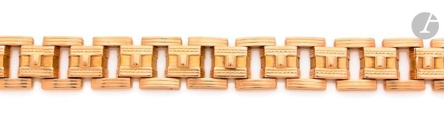 Bracelet en or 18K (750), articulé de maillons quadrangulaires retenus par des barrettes striées bombées. Travail des années 1940. 
Dimensions : 2,4 x 21 cm environ. 
Poids : 100,7 g