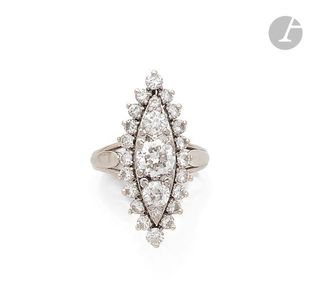 Bague marquise en fils d’or gris 18K (750), sertie de 3 diamants ronds de taille ancienne principaux entourés de diamants ronds plus petits. 
Tour de doigt : 51. 
Poids brut : 6,9 g