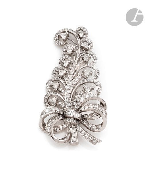 Broche en or gris 18K (750) dessinant une fougère stylisée entièrement sertie de diamants ronds, calibrés et triangulaires. Travail des années 1960.
Hauteur : 6 cm environ.
Poids brut : 20,8 g
Manque.