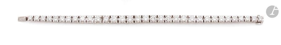 Bracelet articulé en platine, serti de 33 diamants ronds de taille brillant, en chute. 
Longueur : 17,1 cm environ. 
Poids brut : 29,1 g