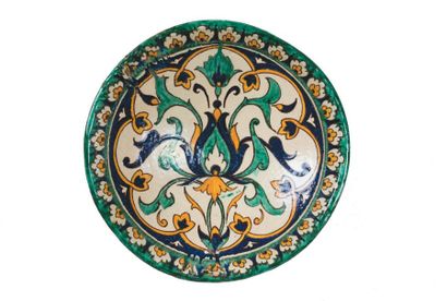 Grand plat creux en faïence peinte en polychromie,...