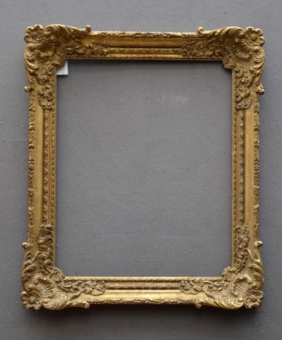 CADRE en bois et pâte dorée à décor de coquilles...