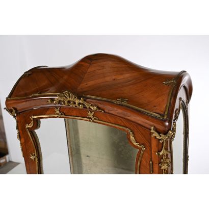 VITRINE 1900 de forme mouvementée en placage...