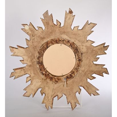 Sun-shaped mirror in gilded and carved wood....