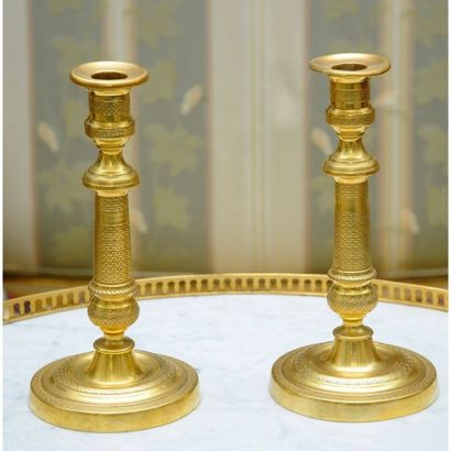 PAIRE DE BOUGEOIRS en bronze finement guilloché....