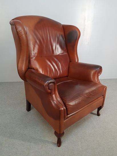 THREE brown leather wing chairs with wooden...
