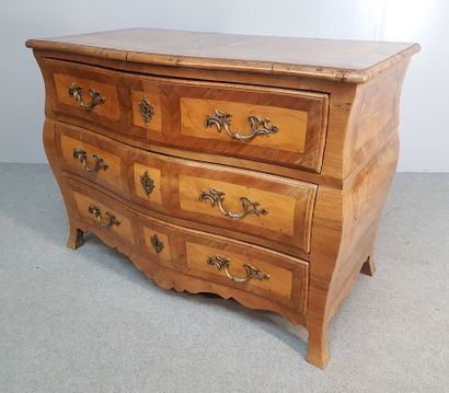 A walnut veneer curved chest of drawers opening...