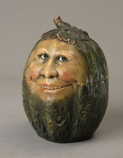 A charming oval-shaped tobacco jar depicting...