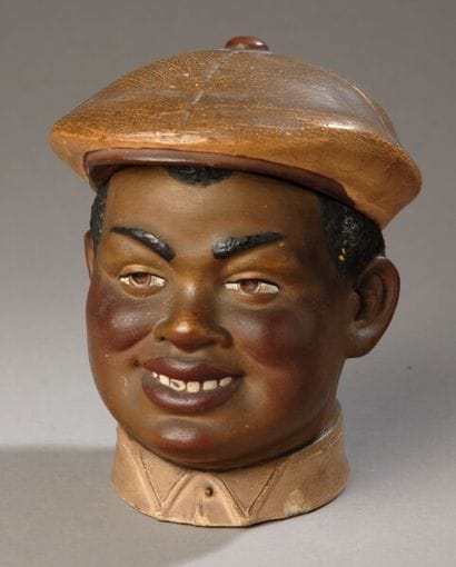 Tobacco jar. The head of a young Black man,...