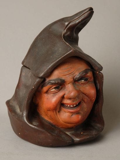 Tobacco jar. A large head of a hooded monk,...
