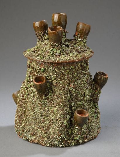 A pot shaped like a conical tree trunk, covered...