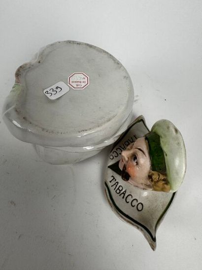 A small pot depicting a grotesque figure...