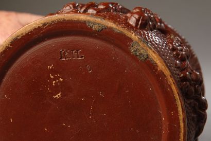 A pot shaped like an antique brown urn, decorated...
