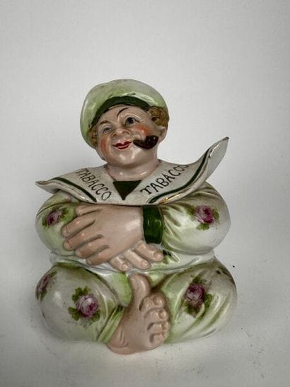 A small pot depicting a grotesque figure...