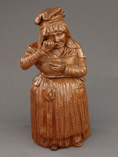 Tobacco jar. Full-length depiction of a sullen...