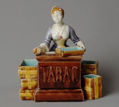 A composite tobacco jar depicting a smiling...