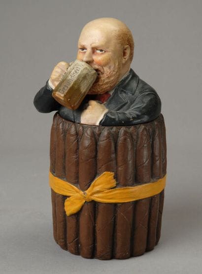 A composite tobacco jar depicting a cheerful,...