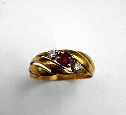 Bague or ornée d'un saphir rose central épaulé...