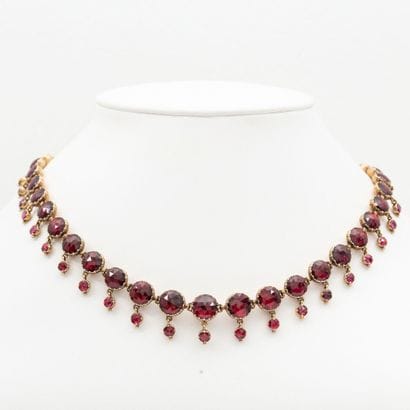 Necklace drapery in light fall, garnets of...