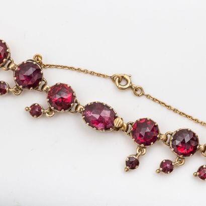 Necklace drapery in light fall, garnets of...