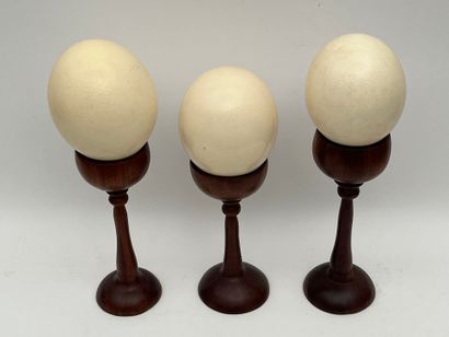 Suite de trois oeufs d'autruche.
Socle bois...