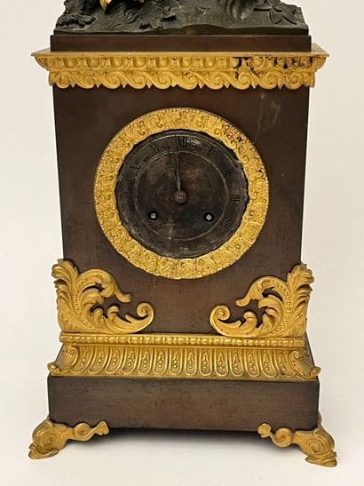 Pendule borne en tole et bronze doré surmontée...