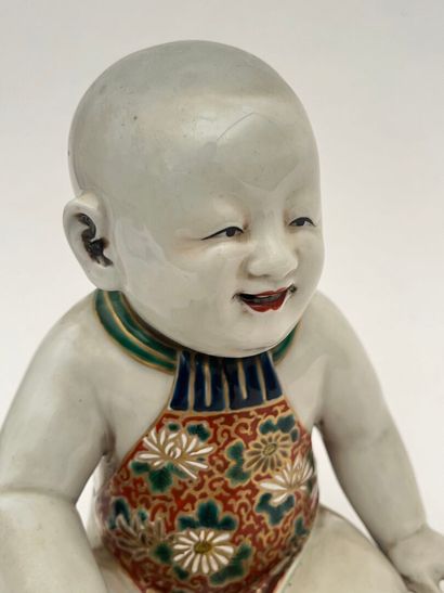 Enfant assis en porcelaine, tenant un oiseau...