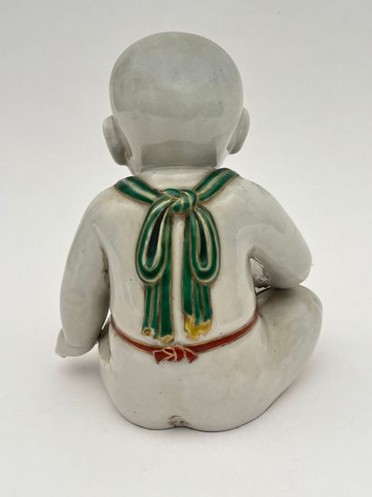 Enfant assis en porcelaine, tenant un oiseau...