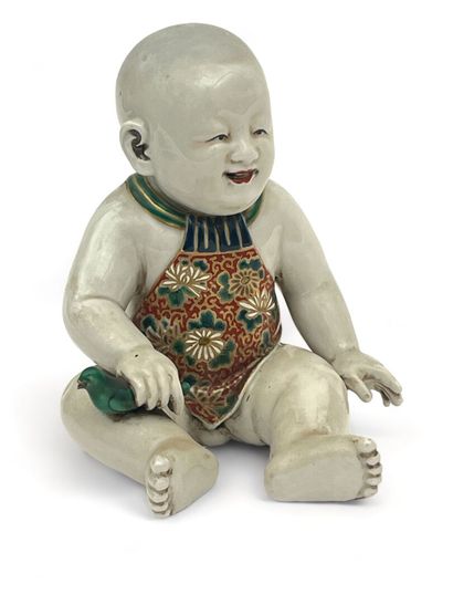 Enfant assis en porcelaine, tenant un oiseau...