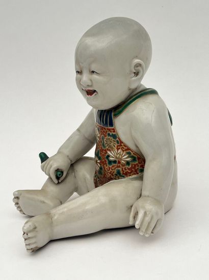 Enfant assis en porcelaine, tenant un oiseau...