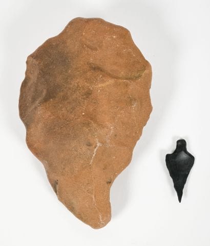 Set of two carved stones, including one arrowhead...
