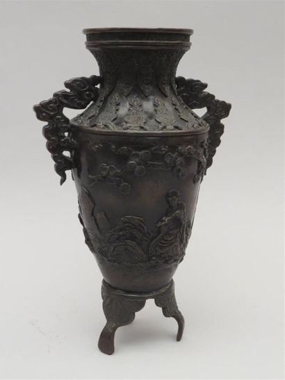 Vase en bronze reposant sur une base tripode....