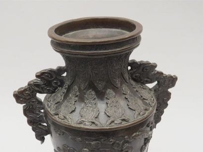 Vase en bronze reposant sur une base tripode....