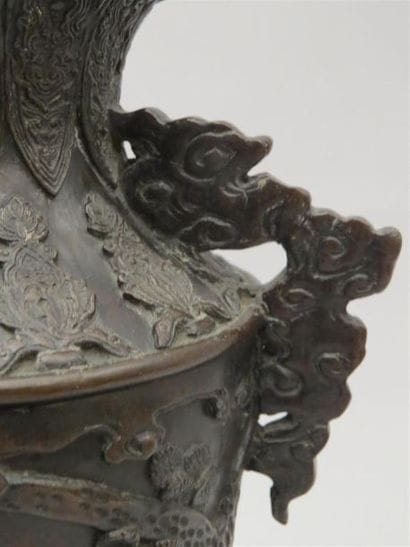 Vase en bronze reposant sur une base tripode....
