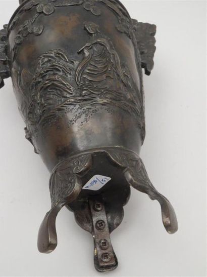 Vase en bronze reposant sur une base tripode....