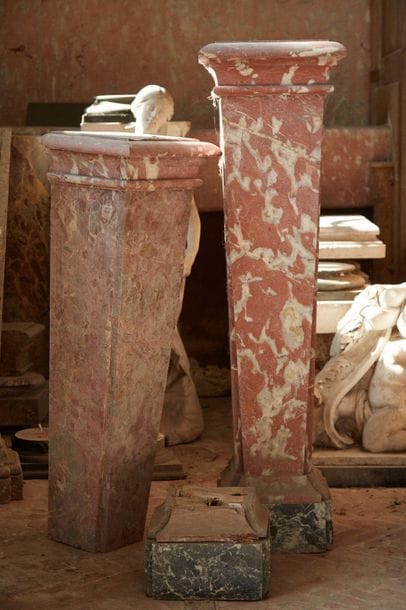 Four columns sheathed in veneer of red veined...