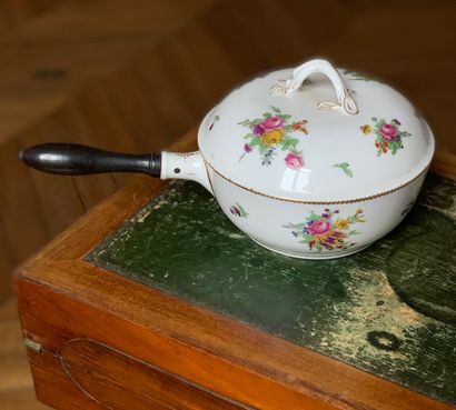 Un poêlon couvert en porcelaine blanche à...