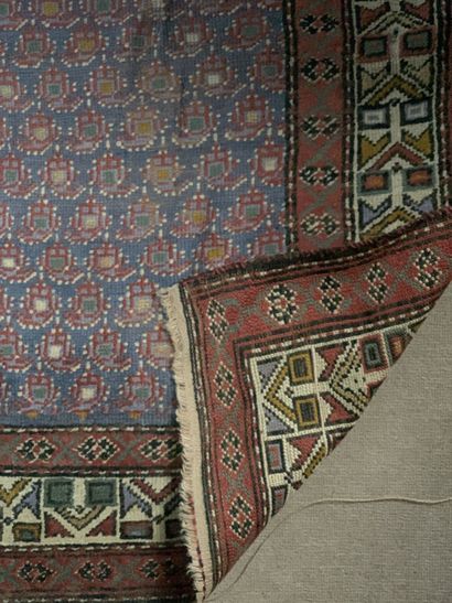 Tapis d'orient à fond bleu et motifs cachemires...