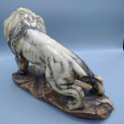 A carved veined alabaster lion, Asian work.

Missing...