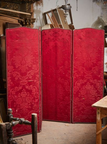 A four-leaf screen lined with a burgundy...