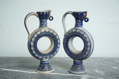 Pair of stoneware pourers with frieze decoration,...