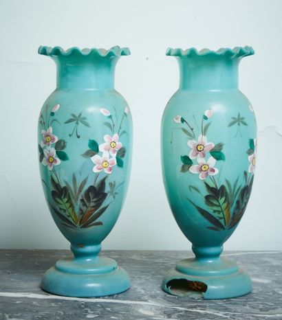A pair of blue glass vases with flowered...