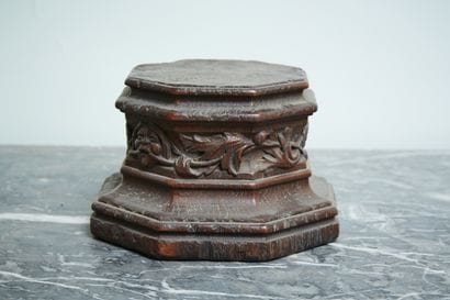 A carved wood octagonal base with a leafy...