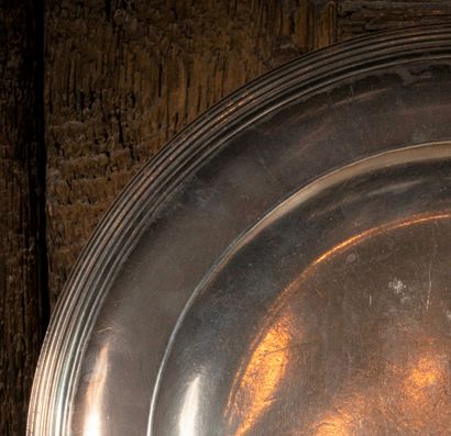 
Plat rond en argent, les bords ornés de...