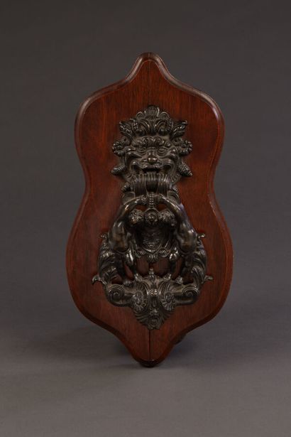 Bronze knocker representing two putti holding...