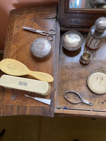 Brushes, glass bottles, one with a silver...