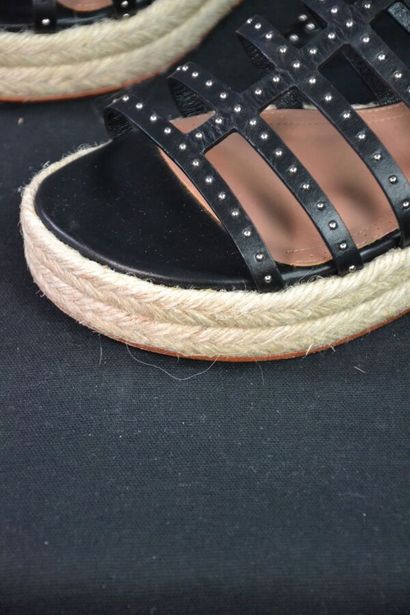ALAIA Sandales compensées en cuir noir clouté....